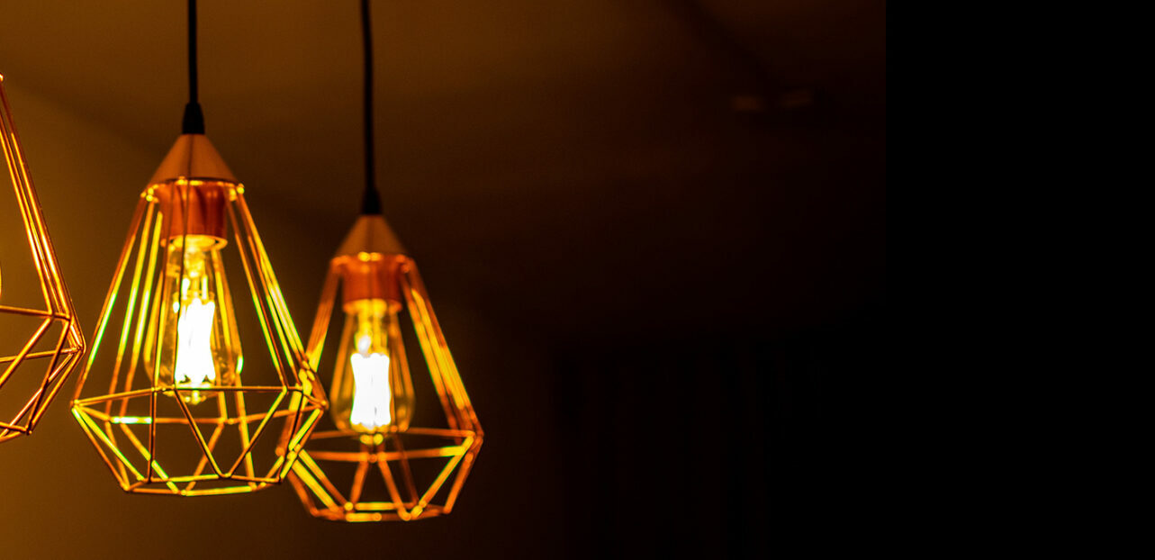 Alt=to hengende lamper med gullramme og glødende lys